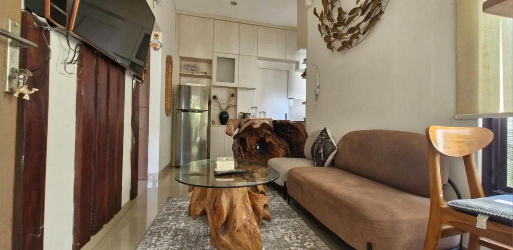 a living room with a couch and a glass table at Cozy 1Bedroom House with Kitchen Work Space in Nusa Dua