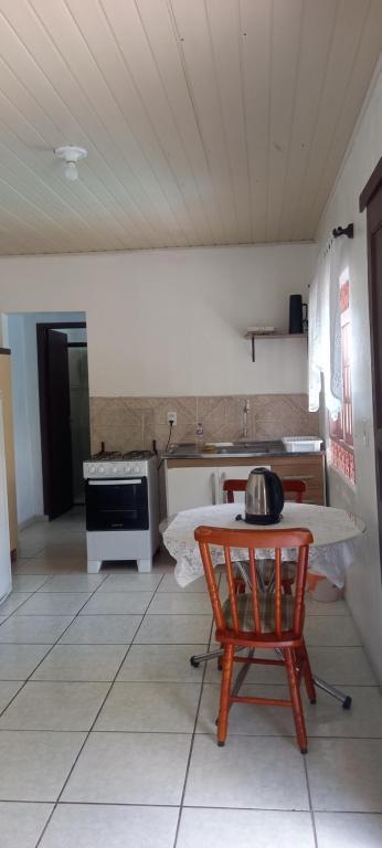 a kitchen with a table and a chair in a room at Espaço da paz in Joinville