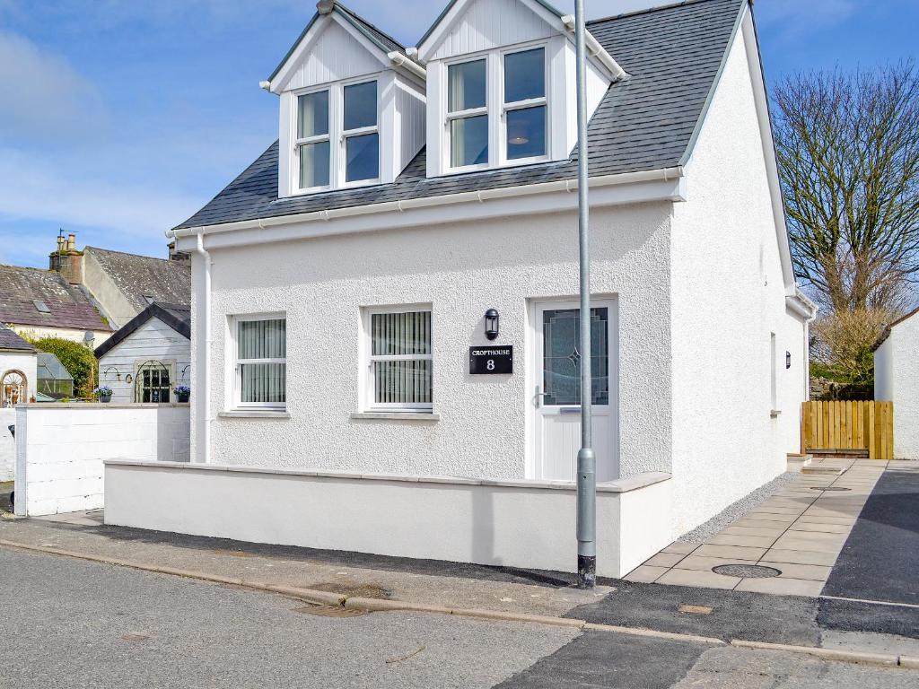 a white house on the side of a street at Crofthouse - Uk43405 in Wigtown