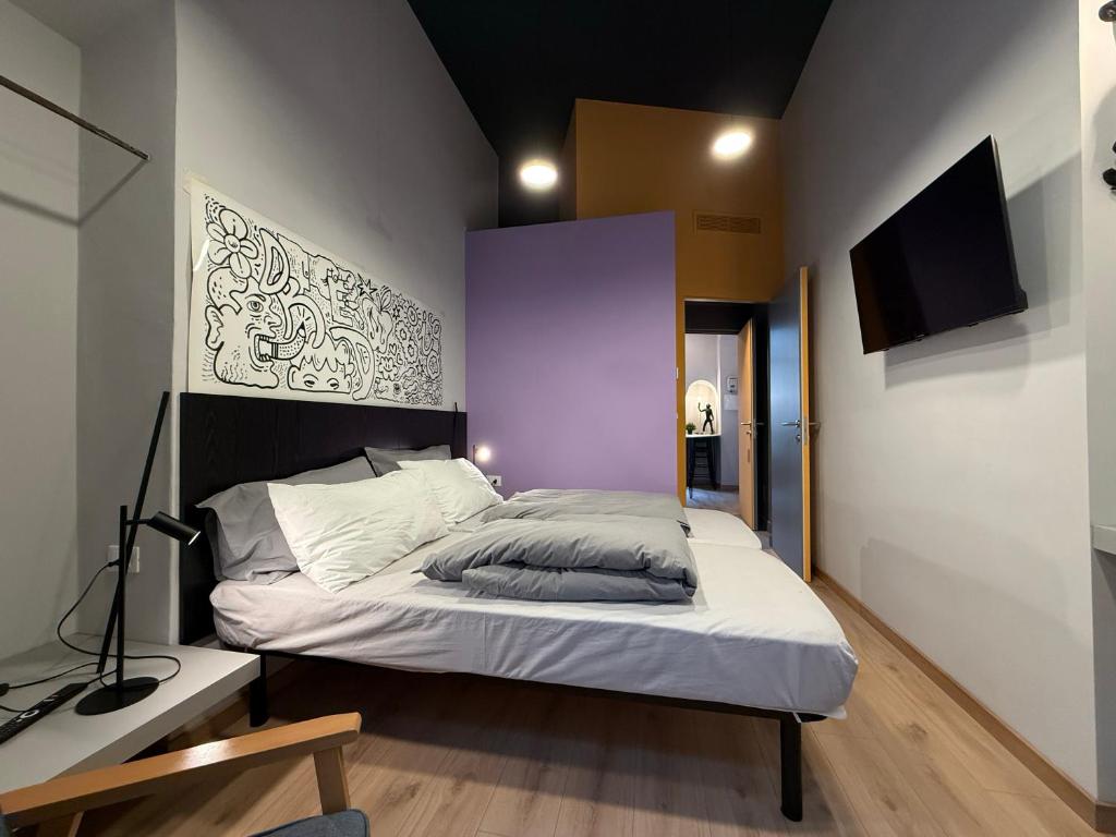 a bedroom with a large bed with a purple wall at THE DESIGNER HIDE OUT - Casa Vacanze in Turin