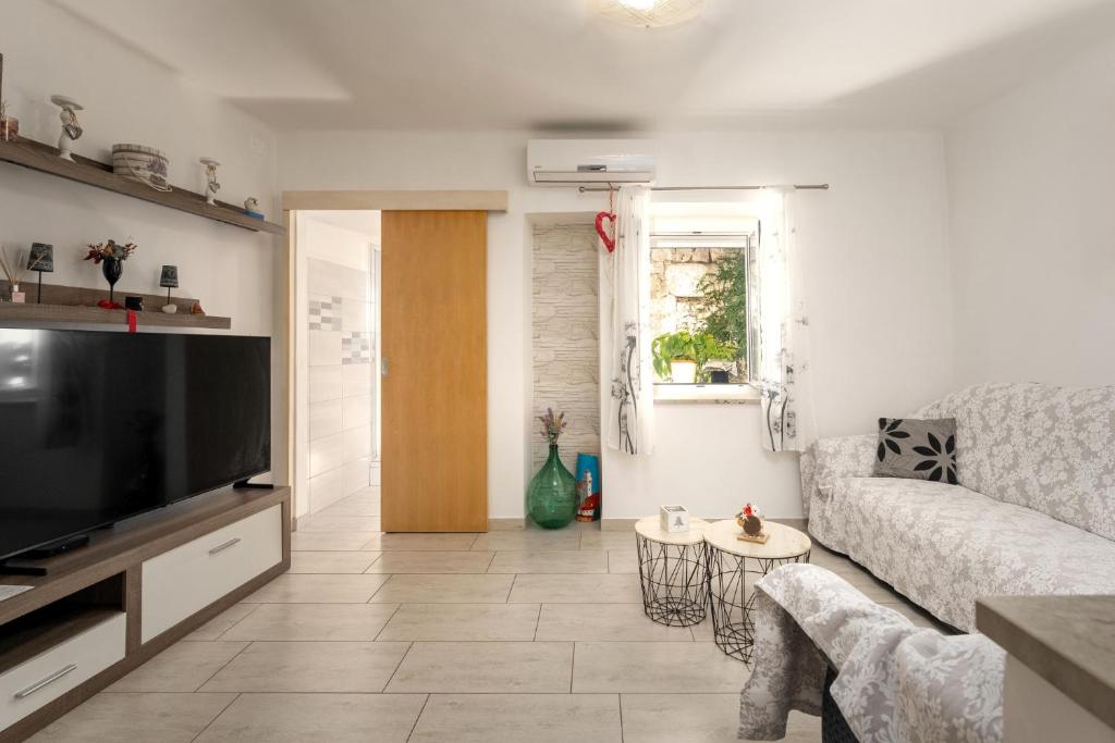 a living room with a couch and a tv at Casa Nadia by Briskva in Mošćenička Draga