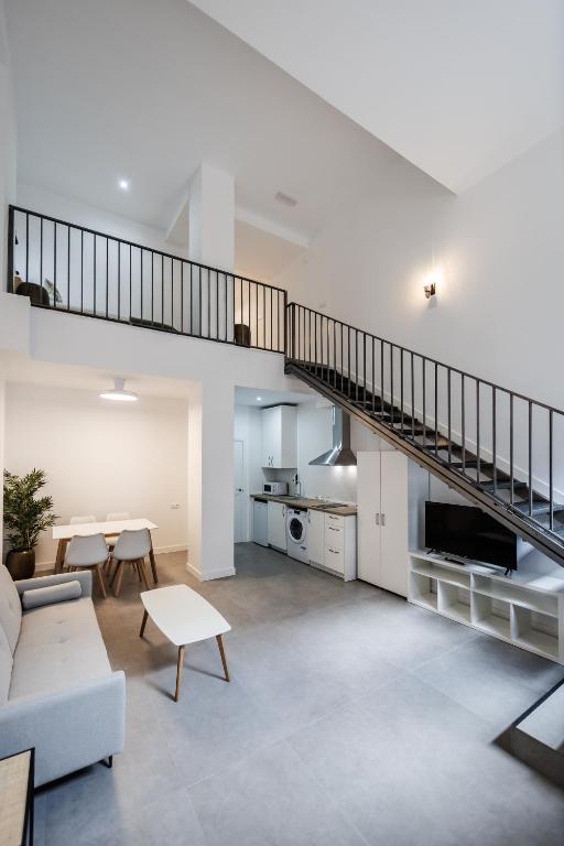 a living room with a staircase and a couch at Apartamentos Cayetana in Badajoz
