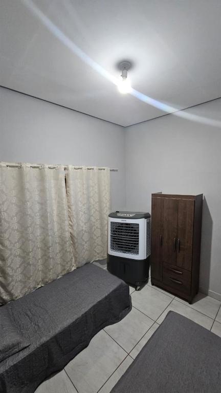 a room with a bed and a television in it at Casa próxima à Praia do Cerrado e centro in Goianésia