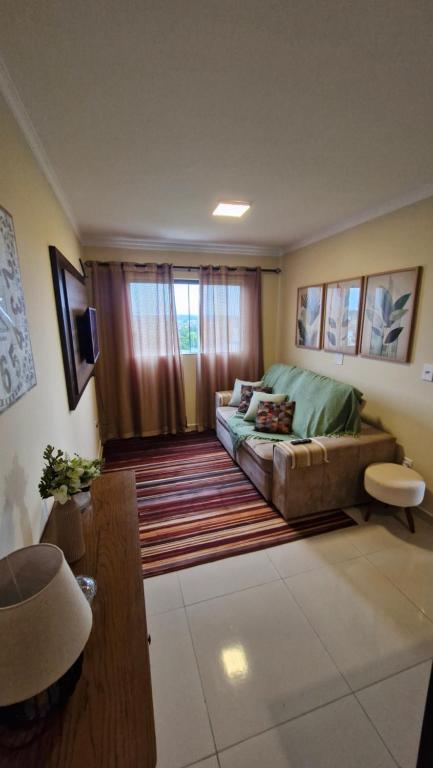 a living room with a couch and a window at Apartamento inteiro in Ponta Grossa