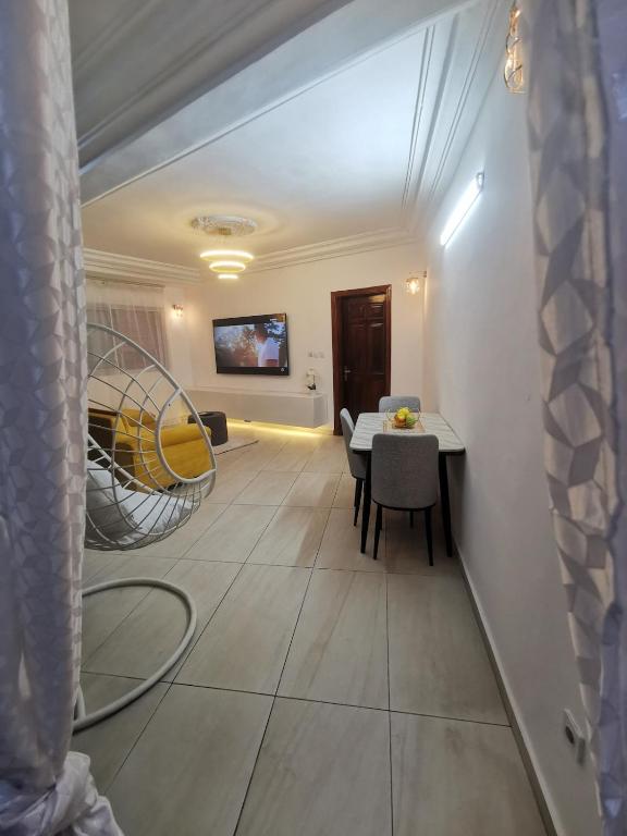 a living room with a table and a chair at Studio VIP - Bonamoussadi - Groupe électrogène - 2douches in Douala