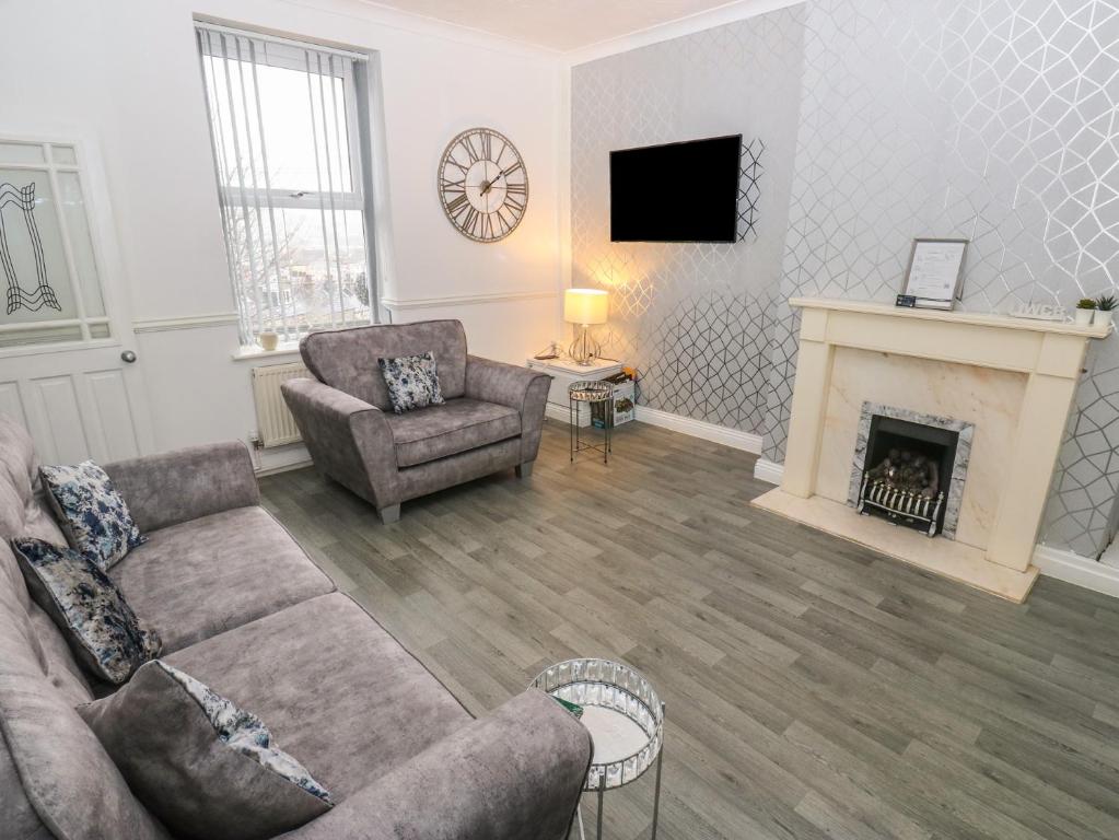 a living room with a couch and a fireplace at Chestnut Lodge in Bradford