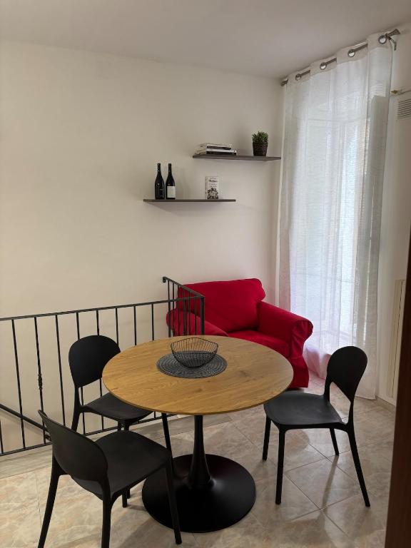a table and chairs in a living room with a red couch at Il vicoletto in Sulmona