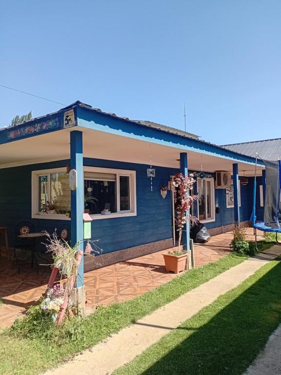 a blue house with a patio in front of it at casa azul in Plottier