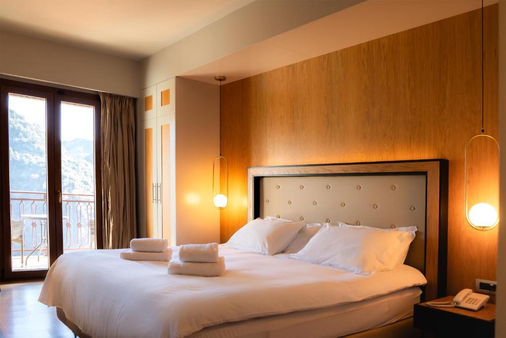 a bedroom with a large bed with towels on it at Lagadia 4 Seasons Hotel in Lagkadia