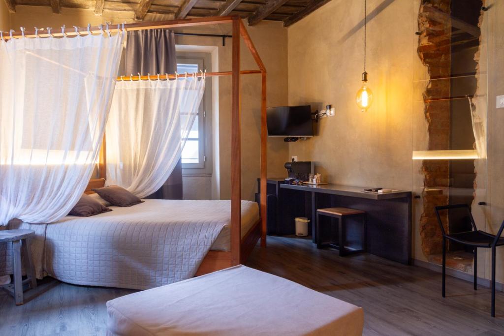 a bedroom with two beds and a television and a window at Dimora Del Teatro in Vigevano