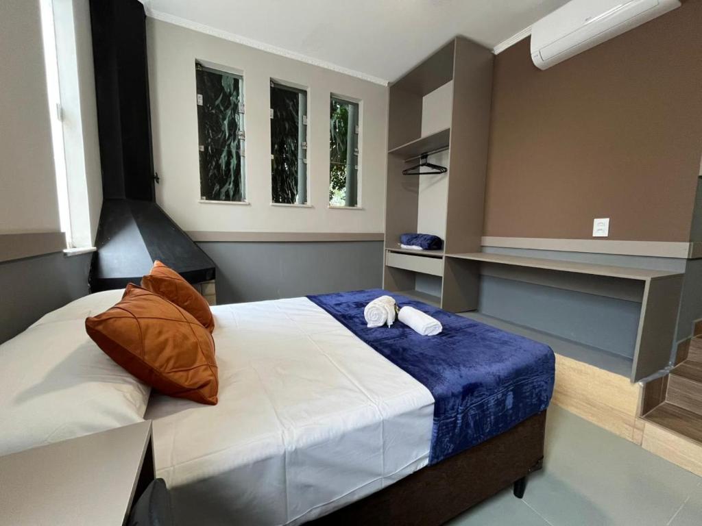 a bedroom with a bed with two towels on it at Astor Suítes - Unicamp in Campinas