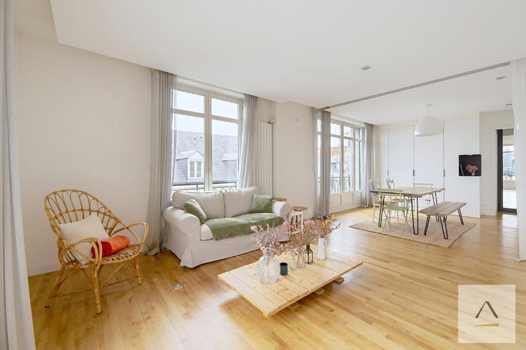 a living room with a couch and a table at Le Palais du Commerce in Rennes