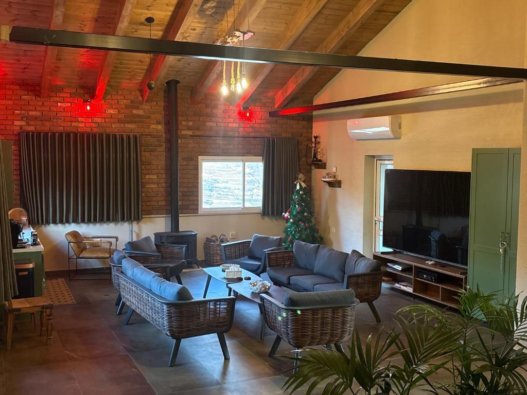 a living room with couches and a christmas tree at Alpinia in Majdal Shams