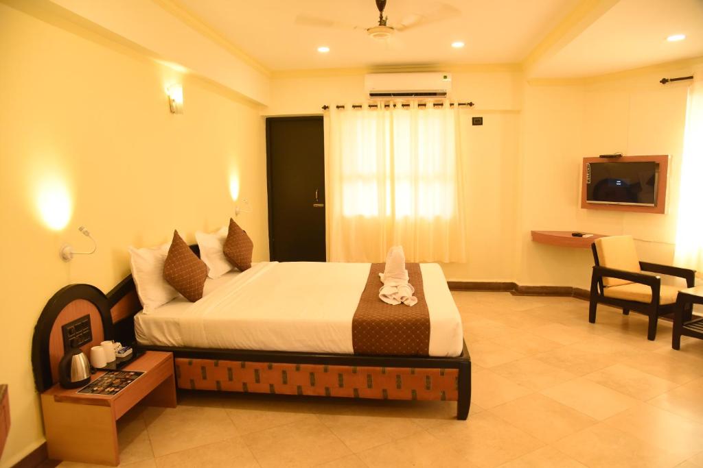 a hotel room with a bed in a room at Om Shiv Hotel Formerly The Treat Hotel in Madgaon