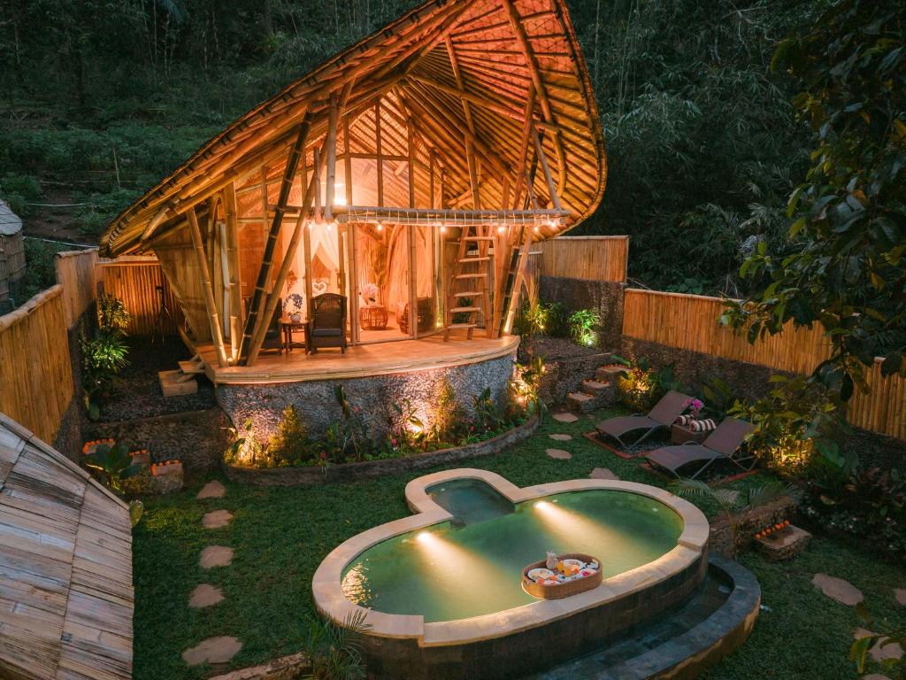 a large bamboo house with a pool in the yard at Sunrise Hill Bamboo House-Private Jungle Villa in Sidemen