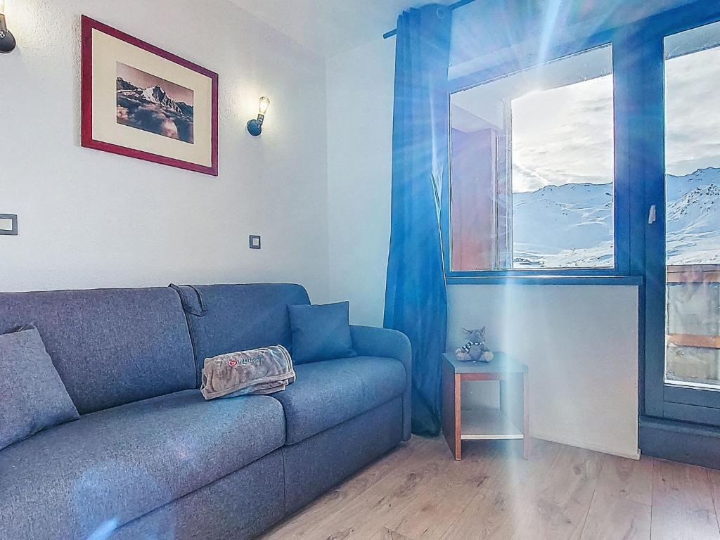 a living room with a blue couch and a window at Studio Les Olympiades-28 by Interhome in Val Thorens
