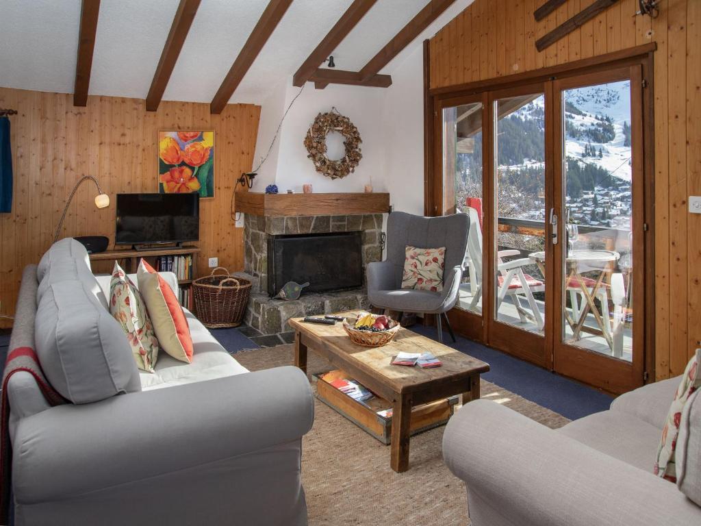 a living room with a couch and a fireplace at Chalet 5 Ecorces by Interhome in Verbier