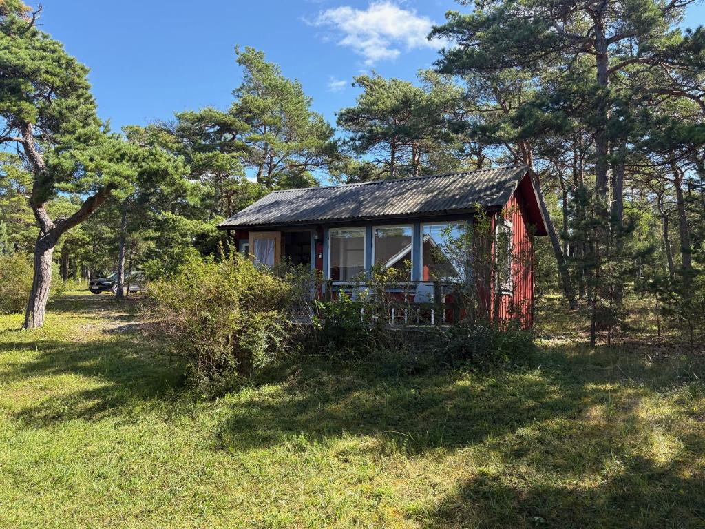 a small house in a field with trees at Liten stuga med havsutsikt in VBY