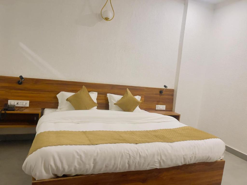 a bedroom with a bed with white sheets and yellow pillows at MADHUBAN STAYS rishikesh in Rishīkesh