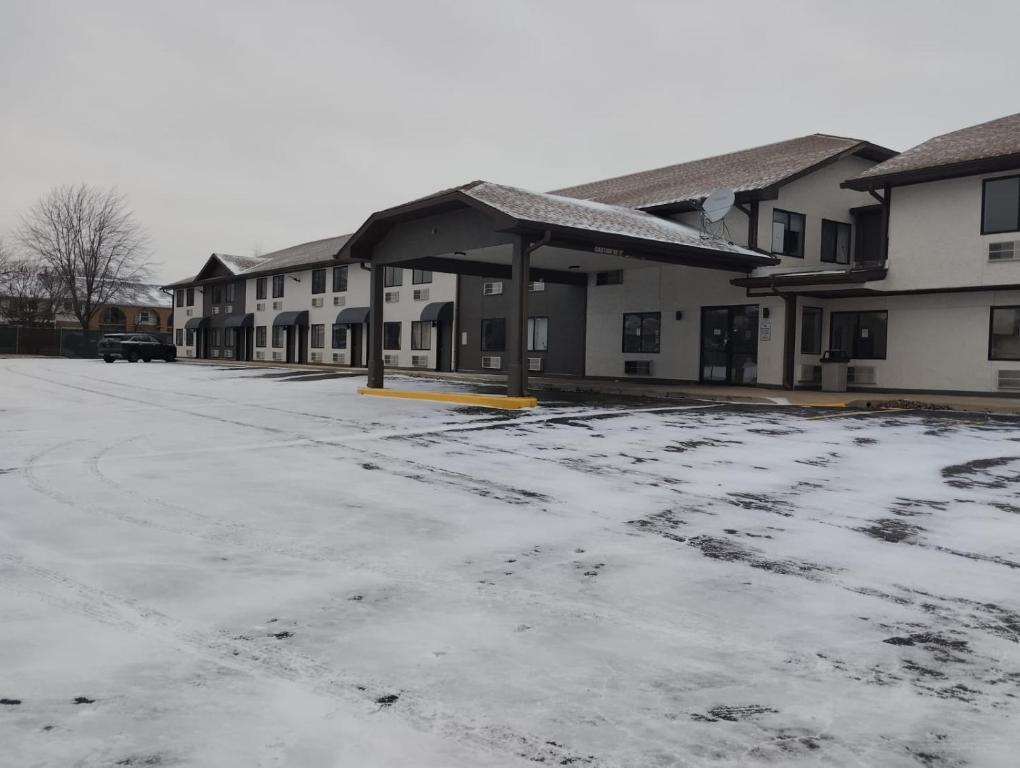 a snow covered parking lot in front of a building at Super 8 by Wyndham Morris in Morris