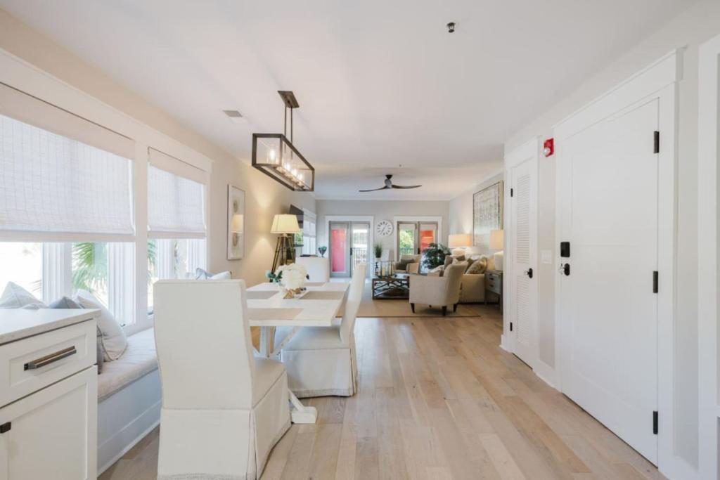 a kitchen and living room with a white table and chairs at Coastal Quarters Condo in Bluffton