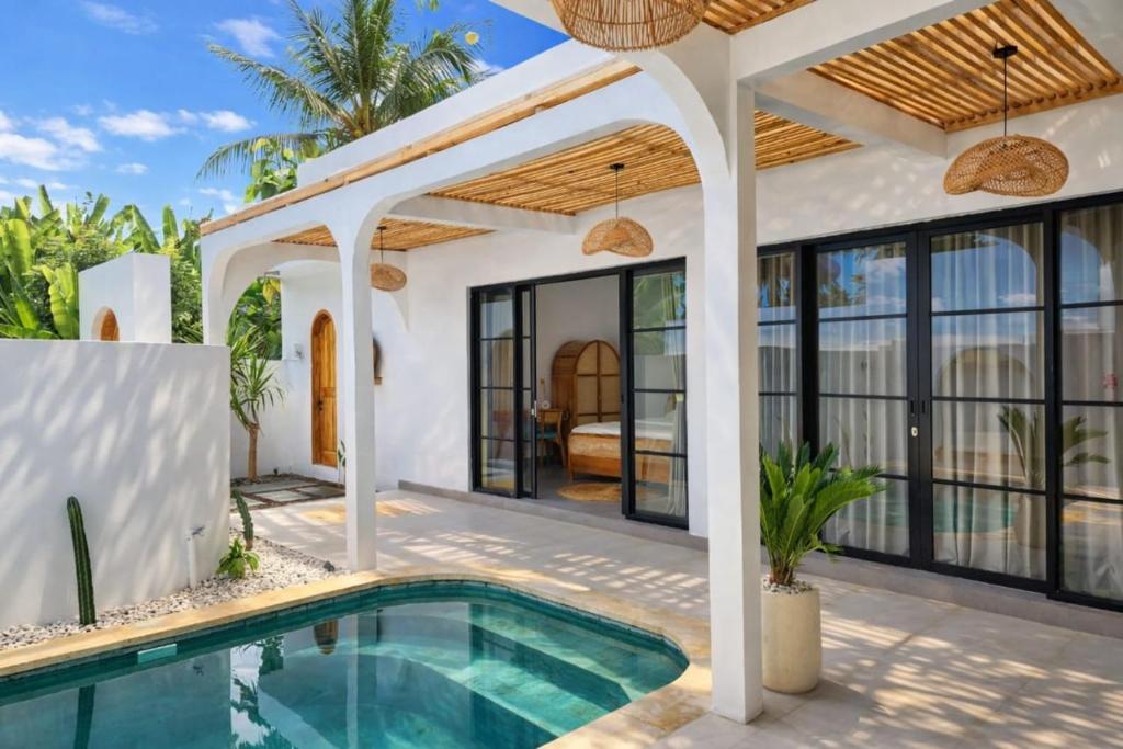 a villa with a swimming pool and a house at Villa Casa de Coco at Lovina in Lovina