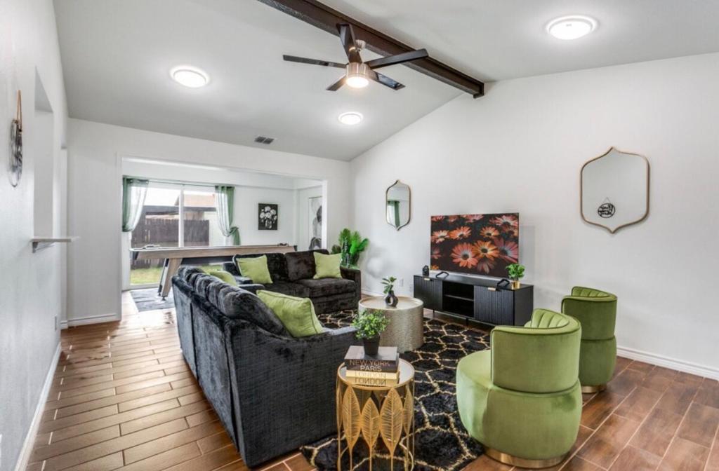 a living room with a black couch and green chairs at Maison Noir Retreat 3B 2B KING in Richardson