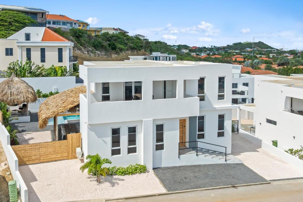an aerial view of a white house at Cura Kaat - Ruime 4 slaapkamer villa met zwembad op gated resort in Jan Thiel