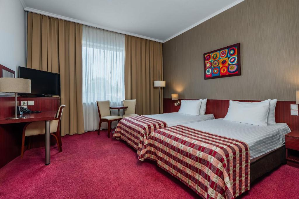 a hotel room with a bed and a desk at Premier Kraków Hotel in Krakow