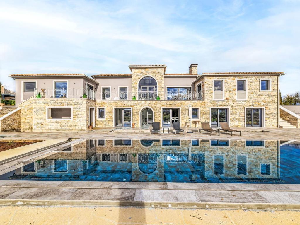 a large house with a swimming pool in front of it at Villa Maison Paradis by Interhome in Višnjan