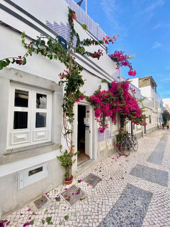 a building with flowers on the side of it at Zenit Olhao baixa one bedroom house sea side view in Olhão
