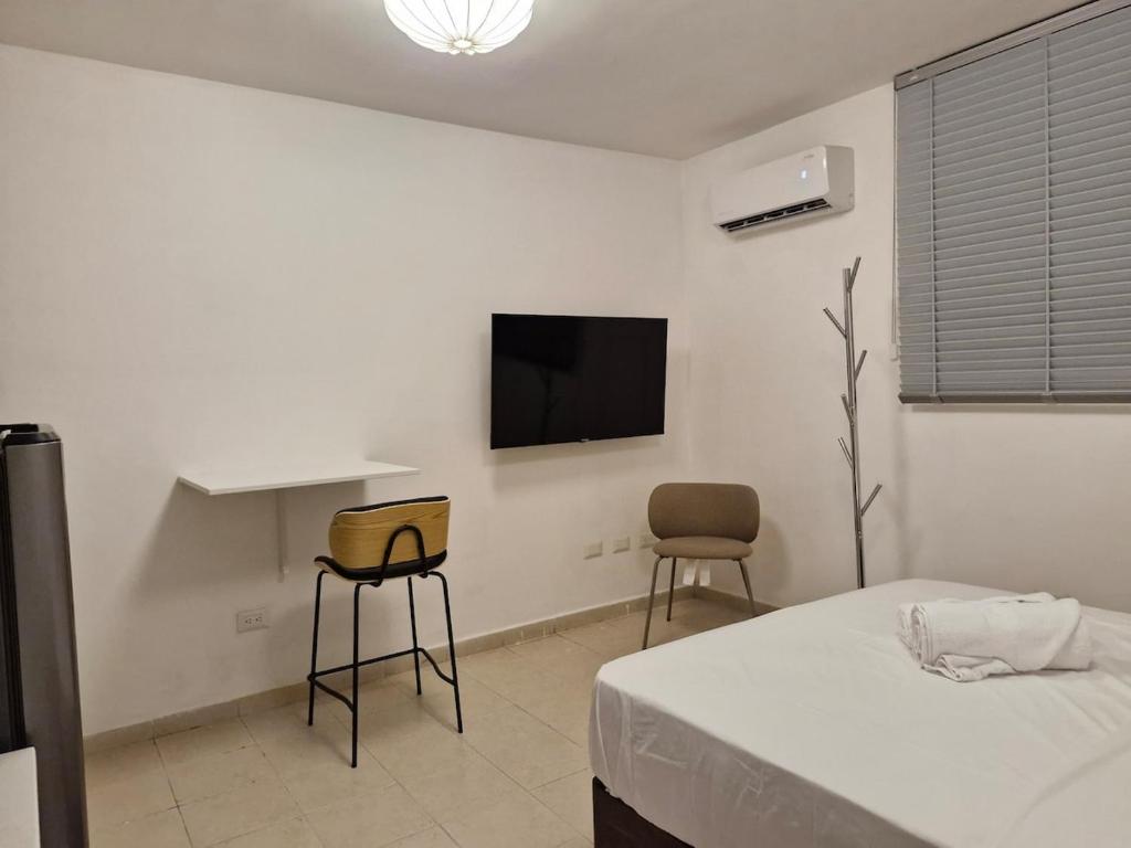 a bedroom with a bed and a tv on the wall at Loft 204 - H54 WAIWA HOST in Bucaramanga