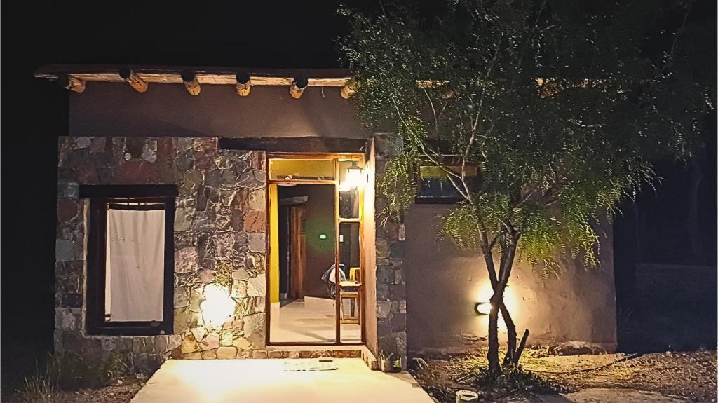 a door to a stone house at night at Cabaña Aklla in Tilcara