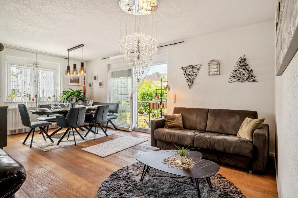 a living room with a couch and a table at Retreat Living - Business-Apartment mit 3 Schlafzimmern, 2 Bädern & Sauna - kostenloser Parkplatz in Bensheim