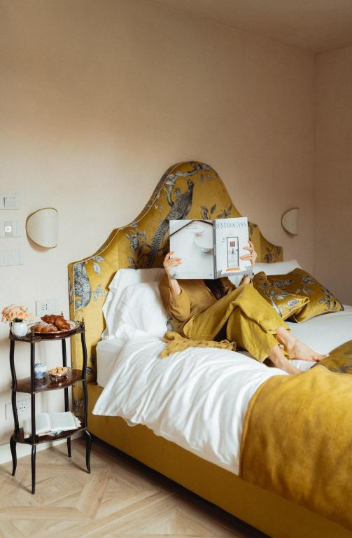 a person laying on a bed reading a book at Dimora Tre Galline in Canale