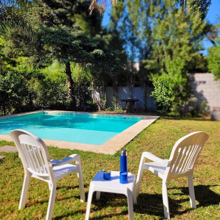 two chairs and a table in front of a pool at Palmeras del sur in Mar del Plata