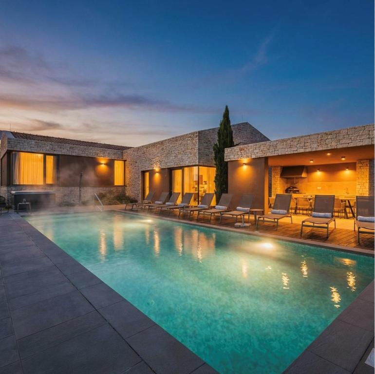 a swimming pool in front of a house at Deluxe Villa with heated pool in Brtonigla