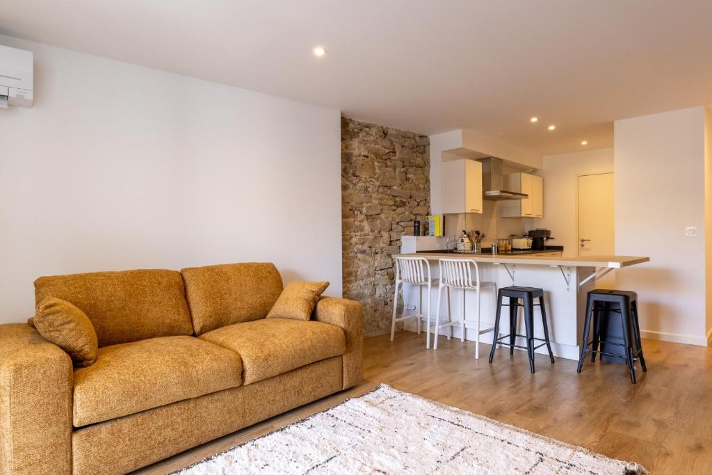a living room with a couch and a kitchen at Duplex Curistes - Conciergerieland in Dax