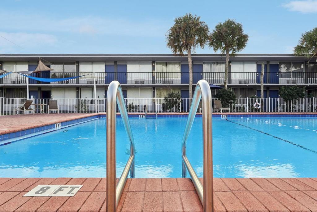 a large swimming pool with a hotel in the background at Stayable Davenport in Davenport
