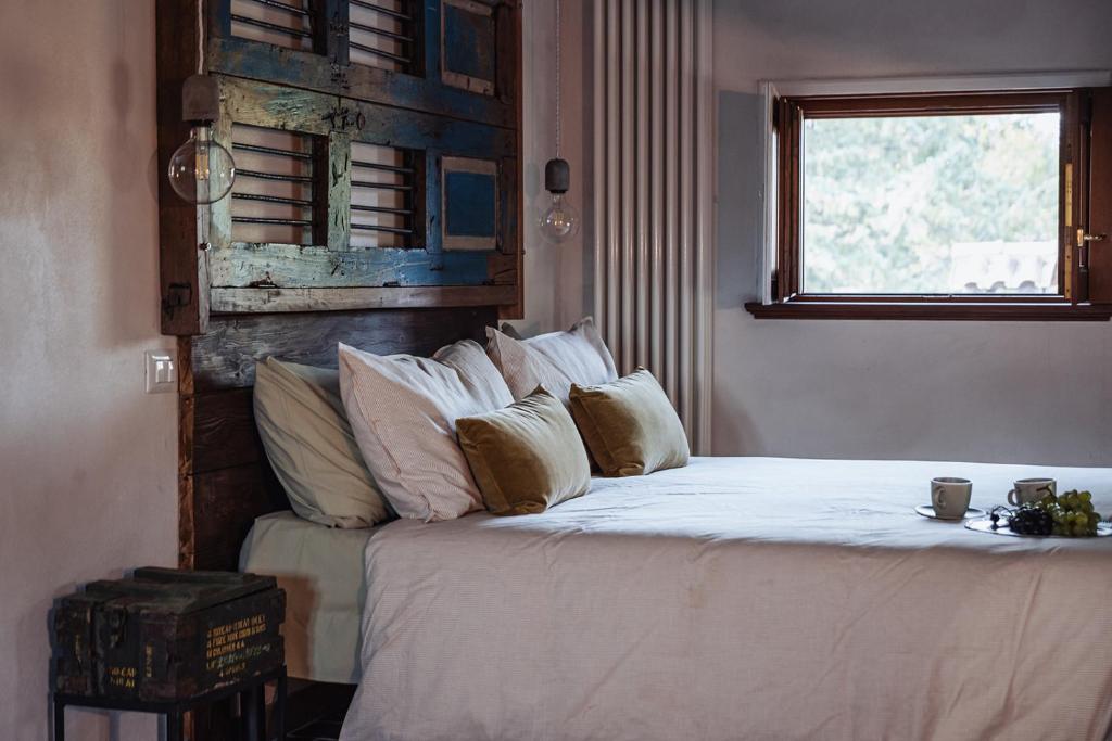 a bedroom with a bed with white sheets and pillows at Casale Tasciotto in Genazzano