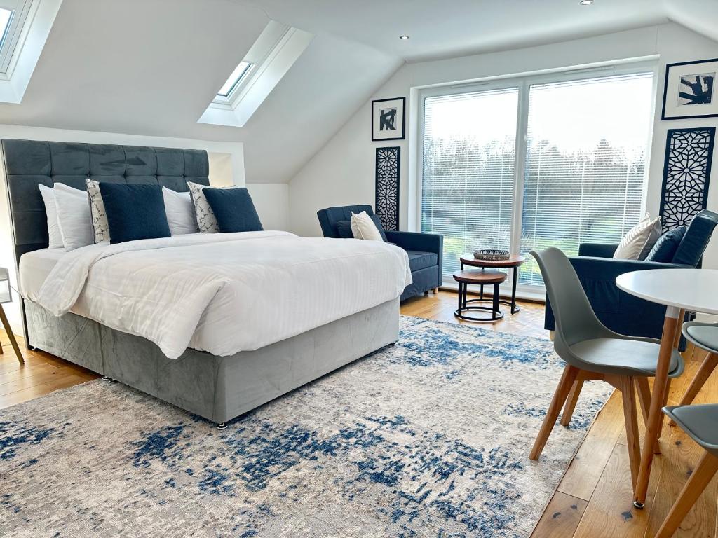 a bedroom with a large bed and a table and chairs at The Wold - Air-Conditionned Studio Burton Latimer in Burton Latimer