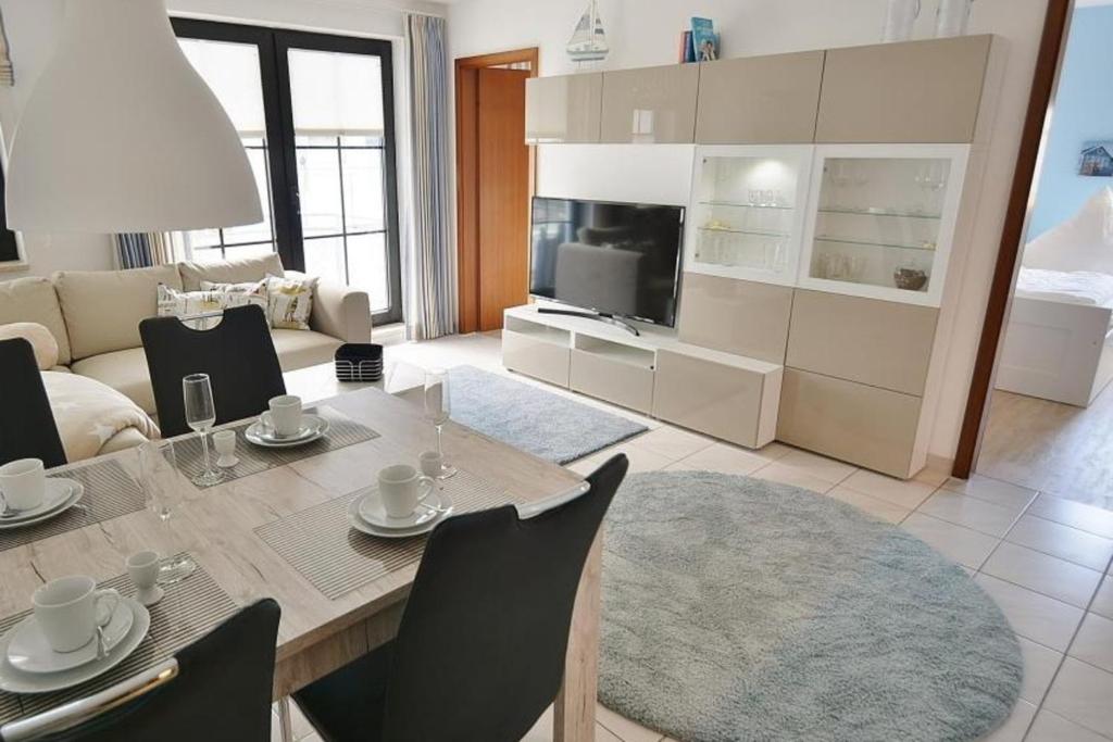 a kitchen and living room with a dining table and chairs at Titania Whg 7 in Grömitz