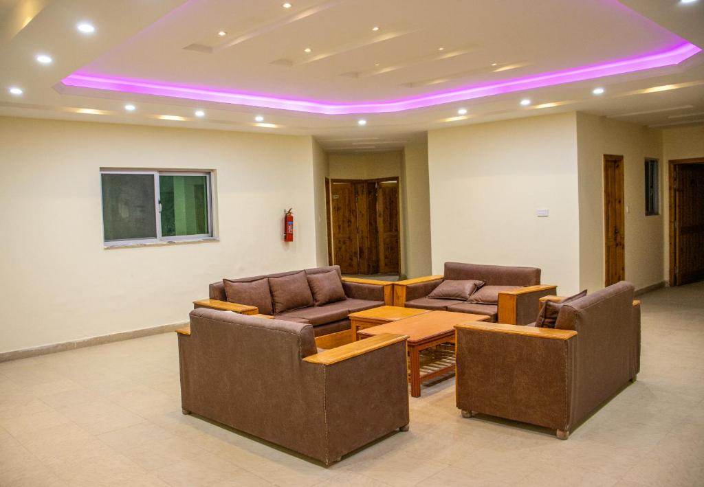 Ein Zimmer mit Sofas, einem Tisch und violetter Beleuchtung in der Unterkunft Hotel Al Azeem in Ayubia