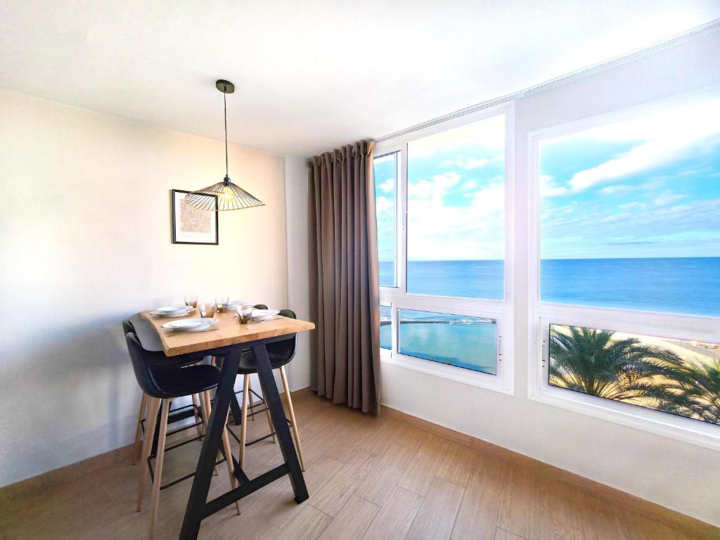 a dining room with a table and a large window at Verana House in Arguineguín