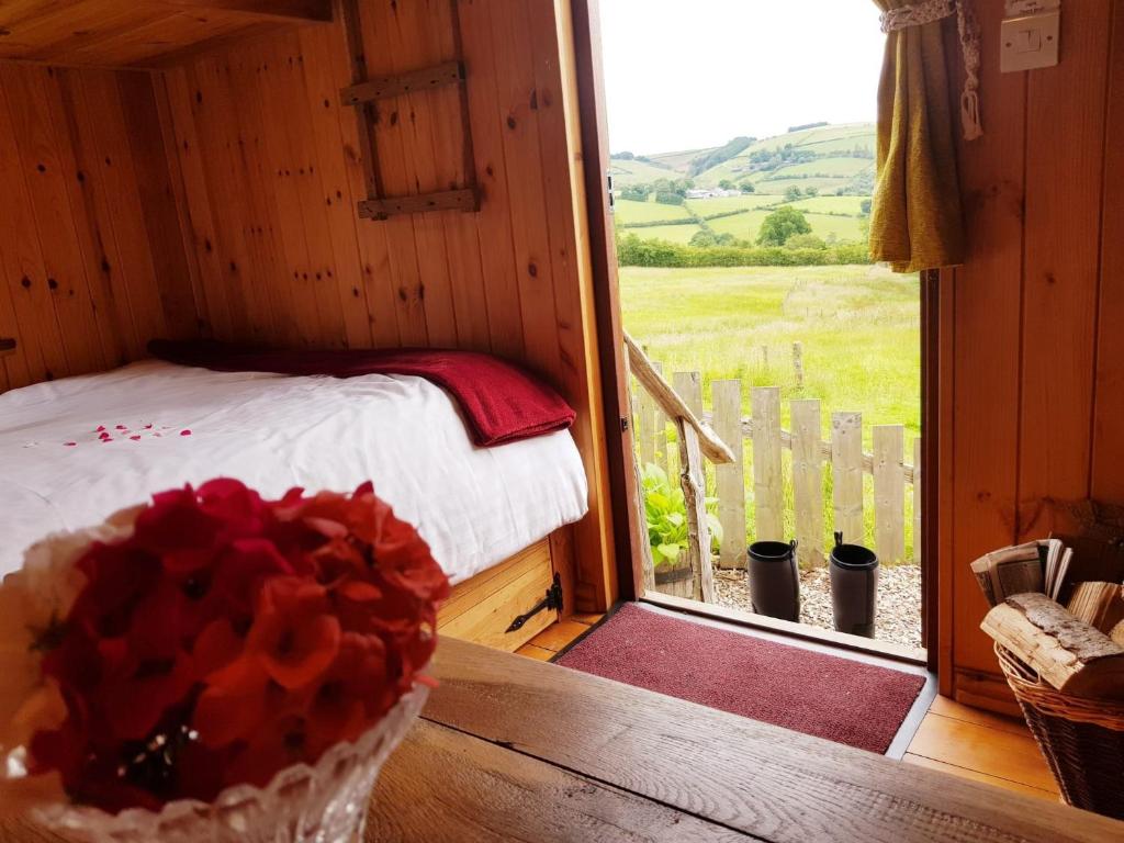 a room with a bed and a window with a view at Beavers Lodge on top of the Shropshire hills in Craven Arms