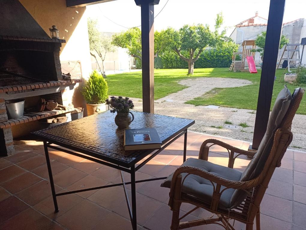 a table and chairs on a patio with a fireplace at Canto del DORMILERO in San Cristóbal de la Vega