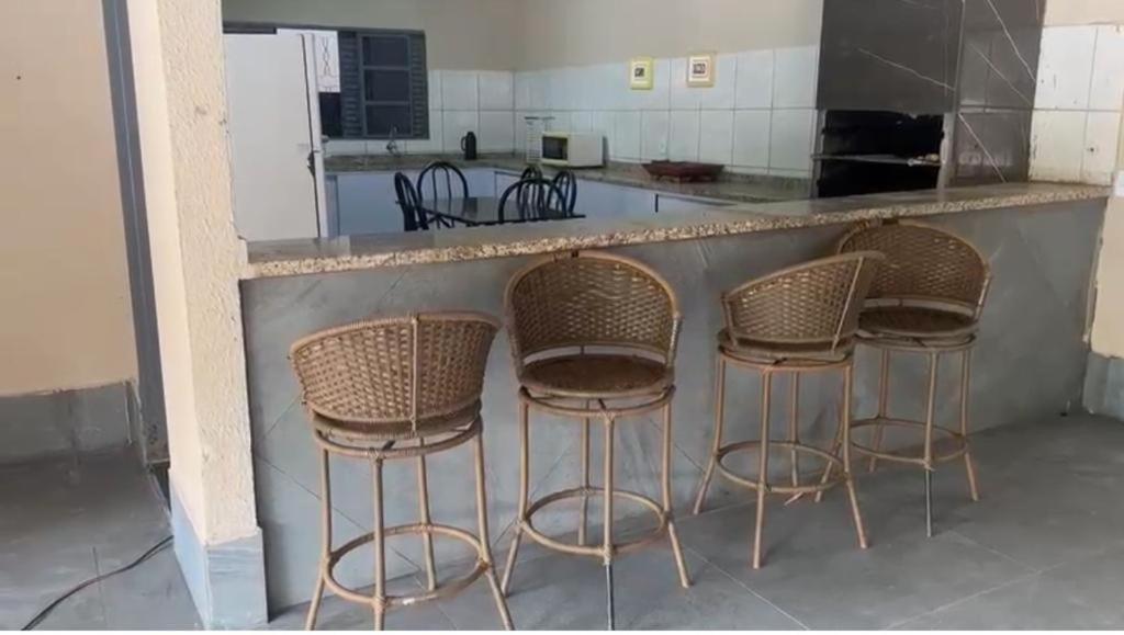 a group of stools sitting at a counter in a kitchen at Chácara Cristo Rei in Senador Canedo
