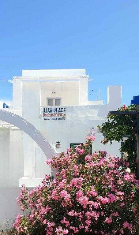 a building with pink flowers in front of a building at Ilias Place in Ios Chora