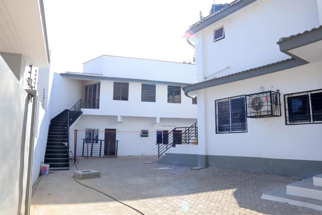 a white building with a staircase in front of it at NyaliHomes in Mombasa