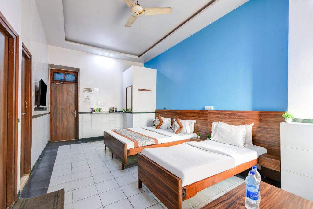 two beds in a room with a blue wall at Hotel New Royal Just Near Old Delhi Railway Station And Red Fort in New Delhi